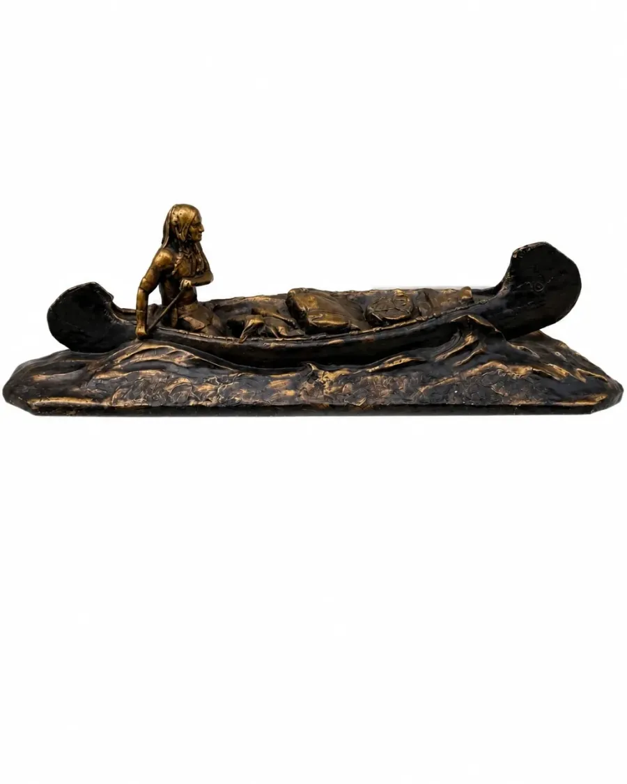 Decorative canoe sculpture with paddler on a stylized wave-like base