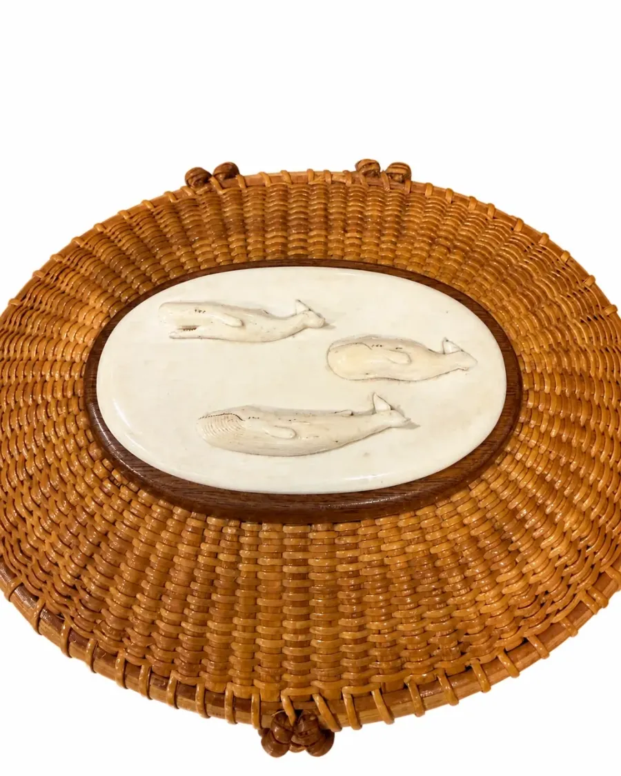 Close detail of the Nantucket lightship basket carved panel with three stylized whale forms